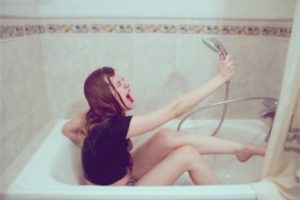 シャワーの水を飲む女